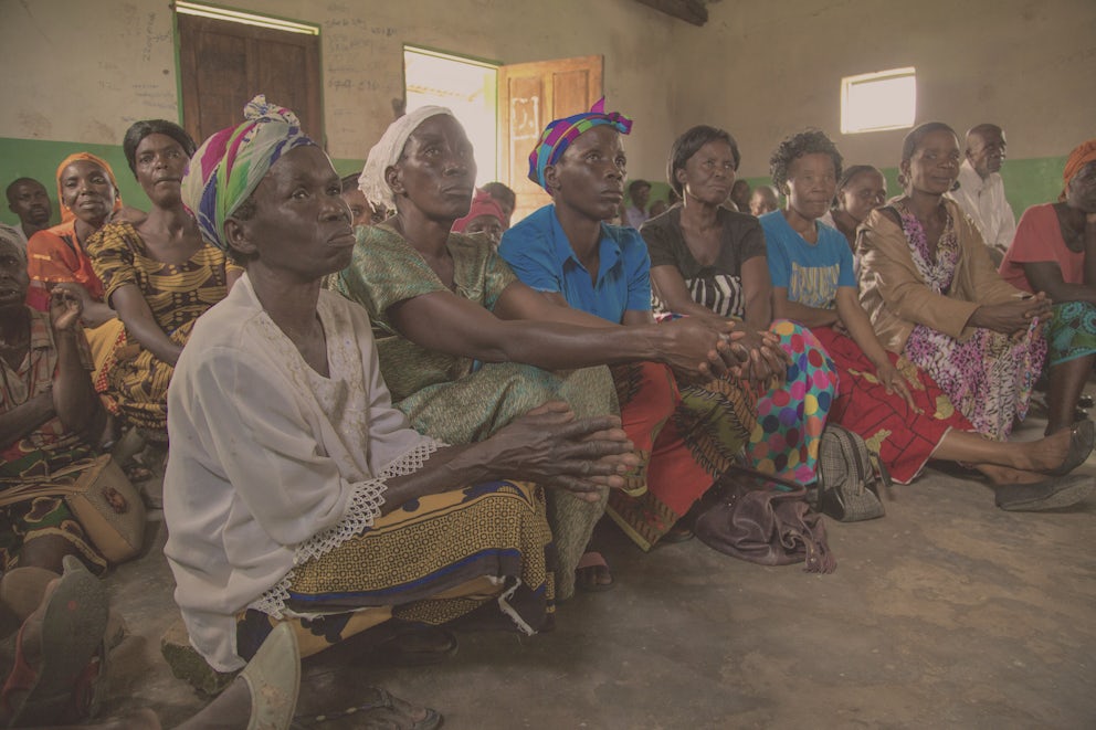 Zambian women indoors listening to a presentation.
