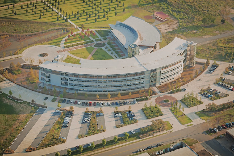 A photograph of Heifer International's campus, a couple of sustainable, semi-circular buildings amid a green landscape.
