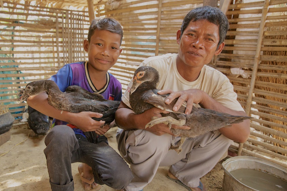 father and son holding ducks