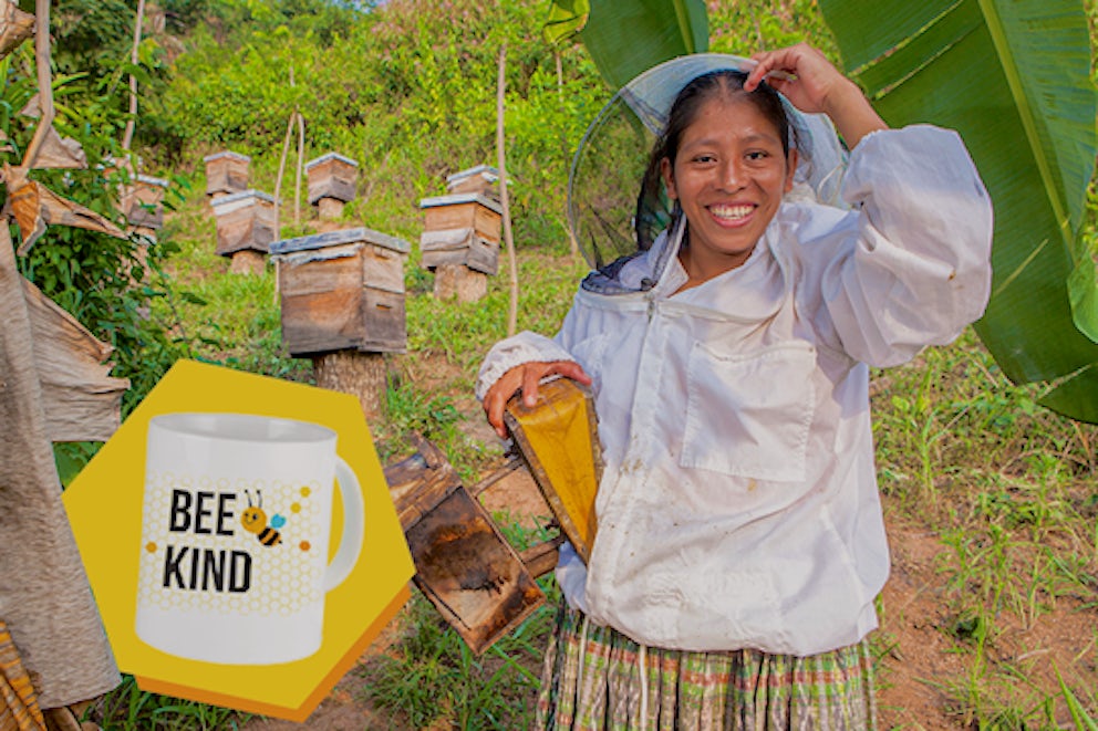 Woman with beehives she received from Heifer.
