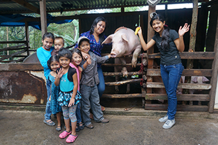 Alba poses with one of her family’s pigs, along with her children, her neices and her newphews.