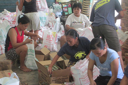 Heifer families unaffected by the typhoon help pack and organize foods for the survivors of Haiyan.