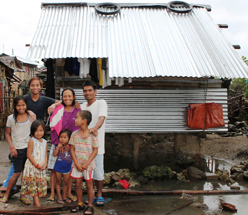 the talle family poses outside their new home