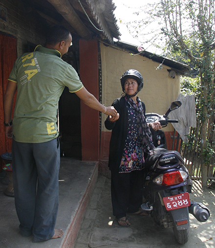Guari Koirala with the scooter she bought with the income from her agro-vet shop
