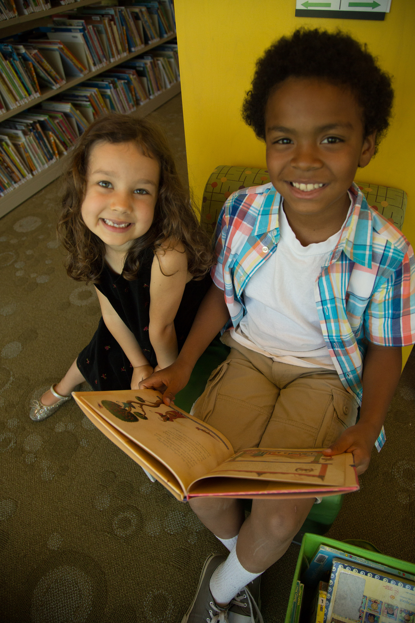 Two children reading in the library.