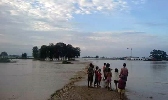 Children find an island in their inundated village.