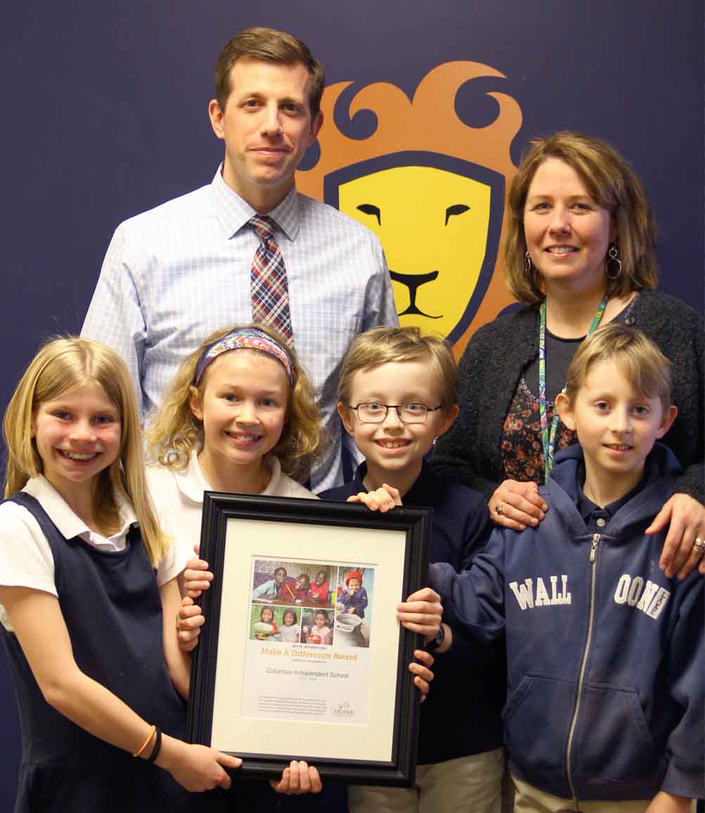 Adam Dubé, Head of School, and Christine Sayers, Lower School Director, celebrate the Make A Difference Award with 4th Grade readers.
