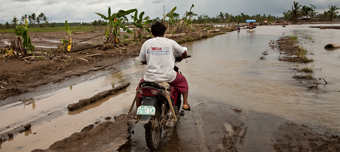 A motorcyclist navigates flood conditions after Typhoon Bopha.