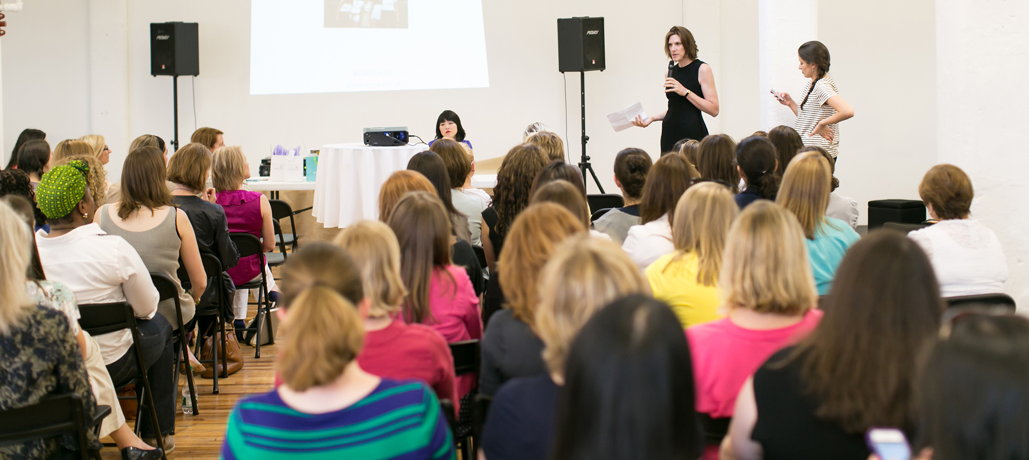 Morra speaking to a crowd of women.