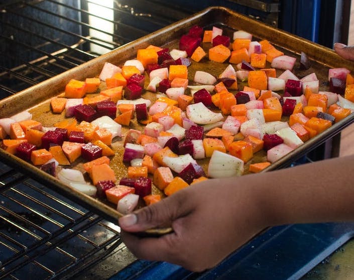 Pan of vegetables going into the oven to roast.