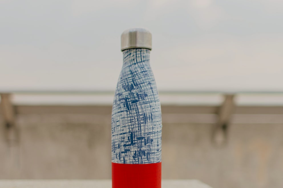 A red and blue stainless steel water bottle.