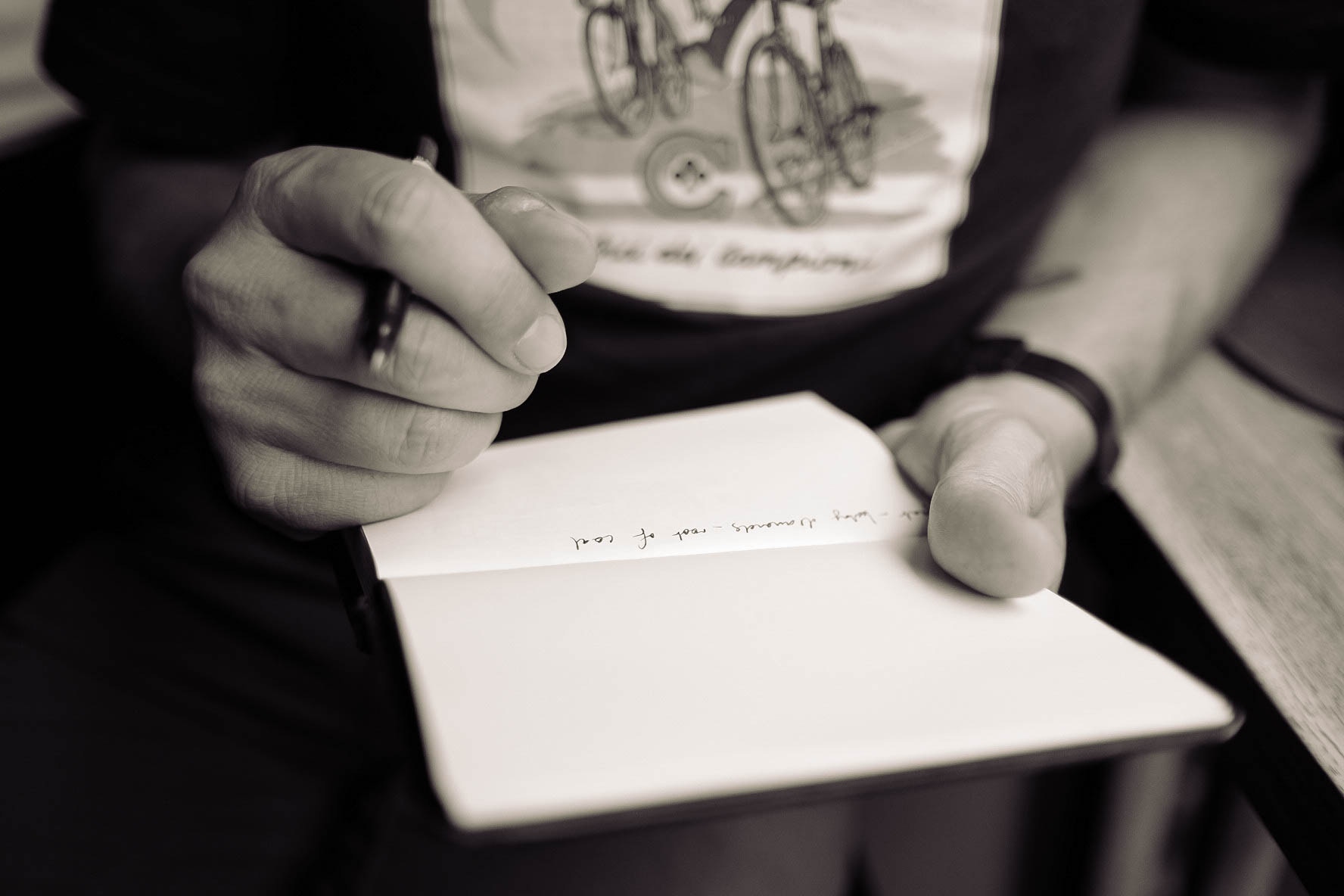 A woman's hands writing in a notebook.