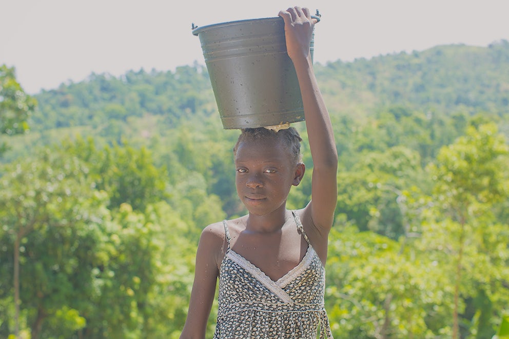 Jilanda Charles (13), fetches water for her family in Haiti every day. Photo by Lacey West.