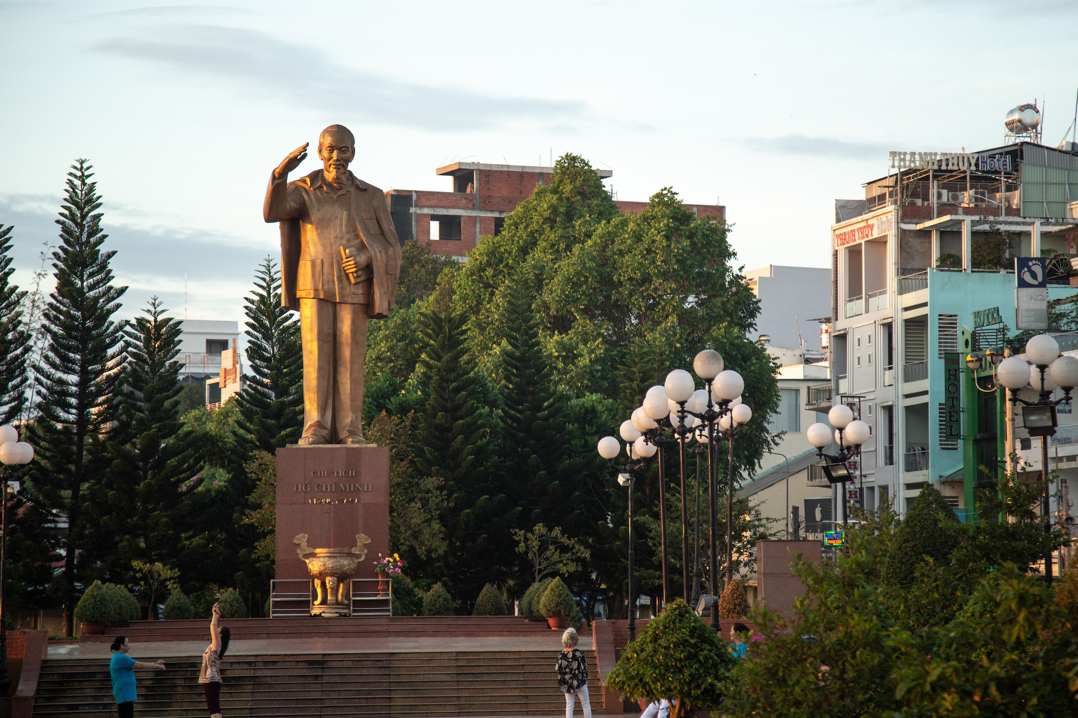 Women gather in front of a statue of Ho Chi Minh to exercise early in the morning in Can Tho City, Vietnam.