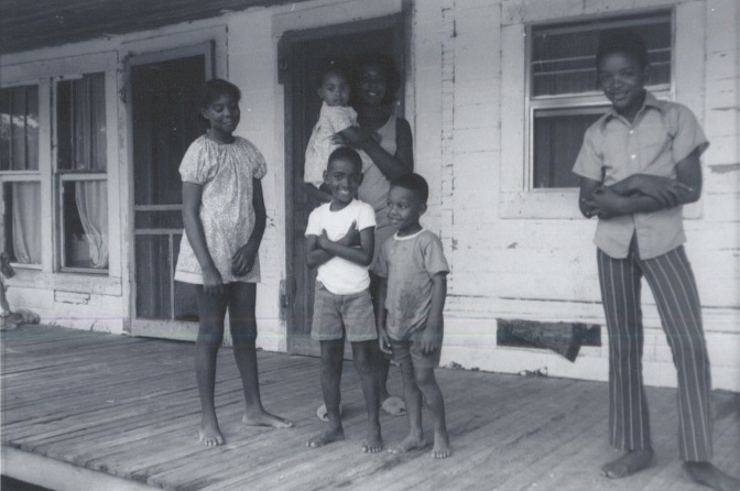 A family involved in the Heifer/Prentiss Institute project in front of their home