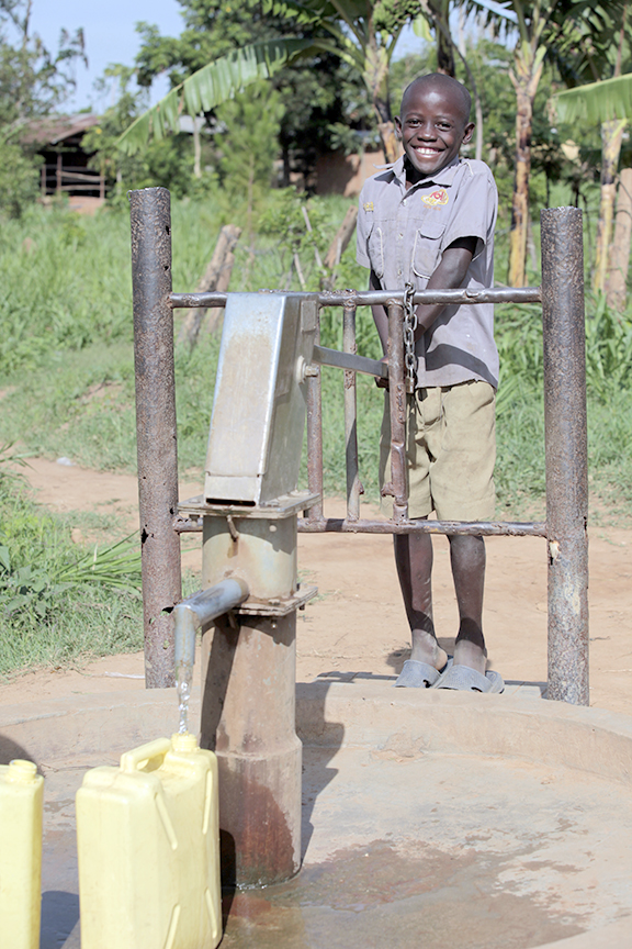 Nine-year-old Rahim pumps water in Kilulu village.