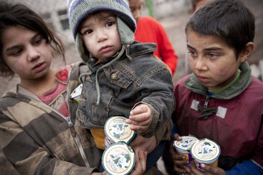 Children in Pata Rat, Romania, receive a gift of yogurt from Heifer farmers.