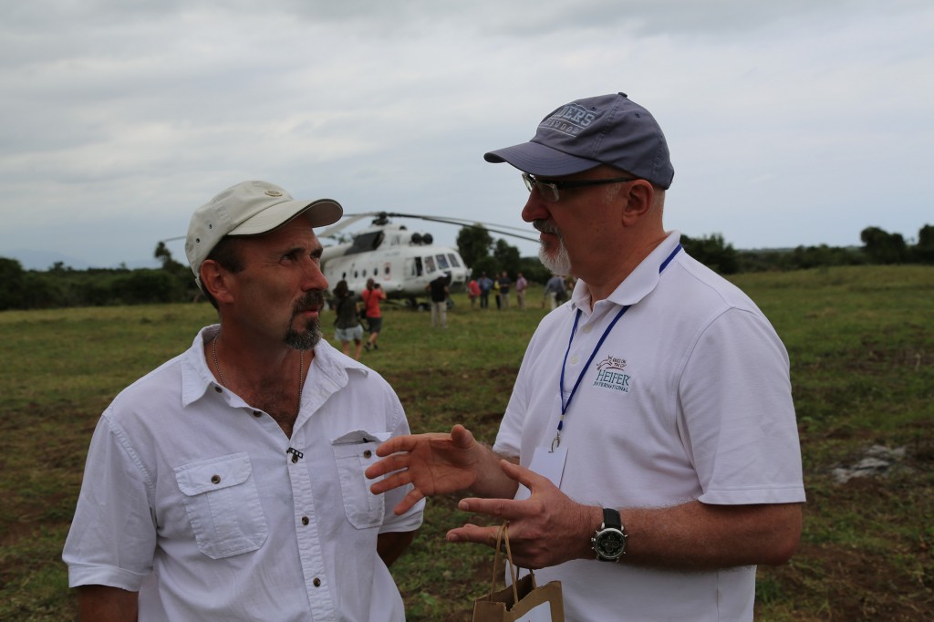 Andy English of North Coast Development and Heifer CEO Pierre Ferrari chat as a U.N. helicopter warms up for departure.