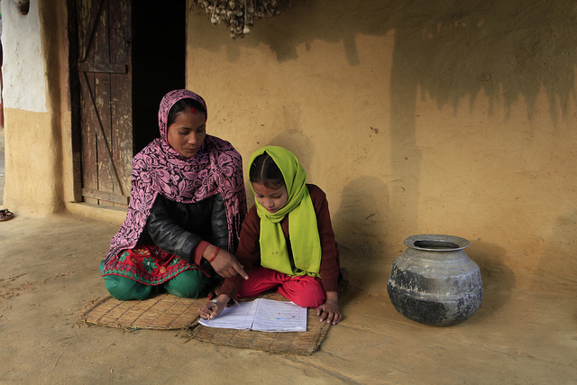 Gender gaps in literacy have closed through MDG-related efforts. Manu Rasaili helps her daughter Mira Sunwar with her school work in Tleyanpur Village, Nepal. Photo courtesy of Heifer International.