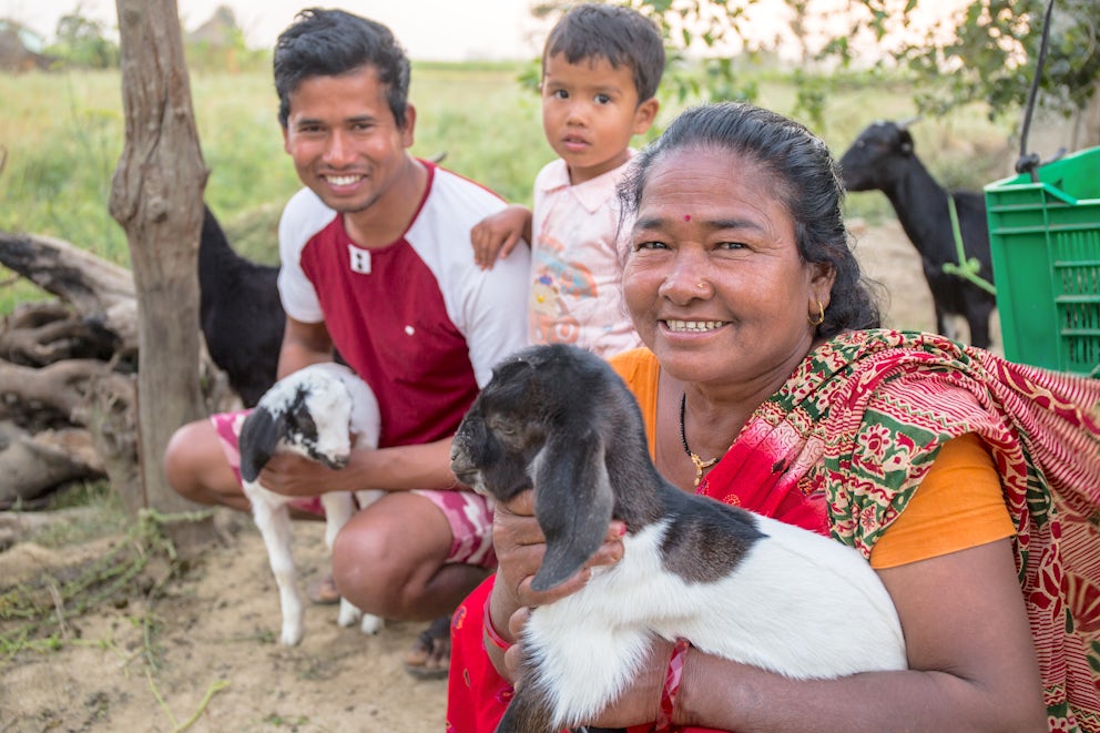 Jit and her family holding their goats and smiling