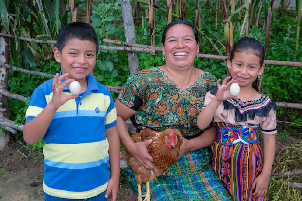 Mother and children with chicken and eggs that they received from Heifer