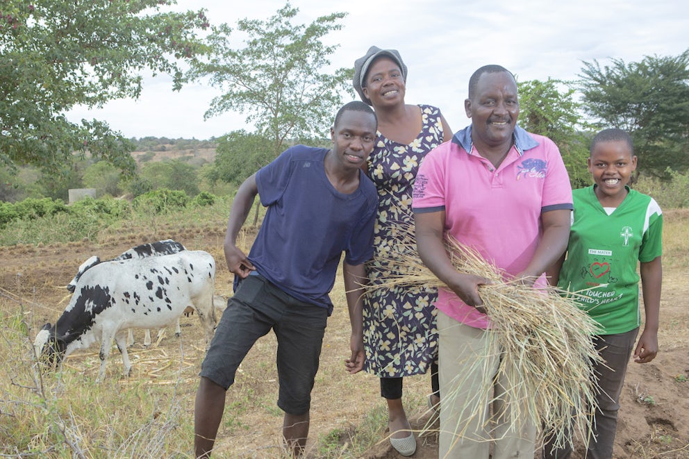 Janet standing in front of a cow with her family
