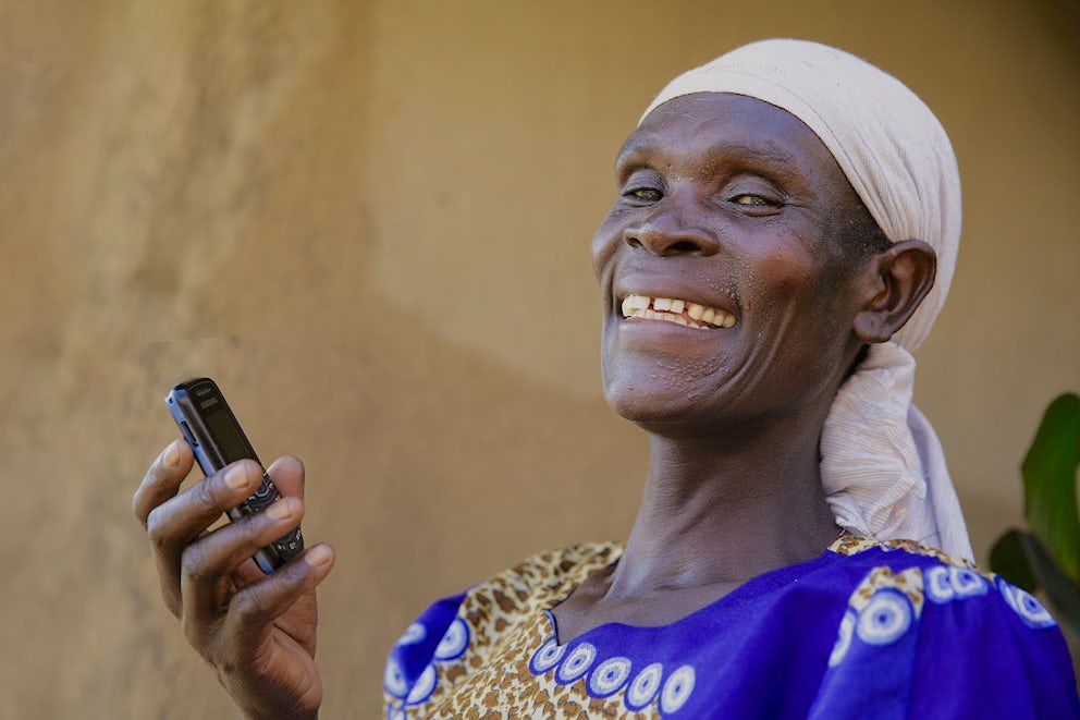 Kenyan woman holds cell phone