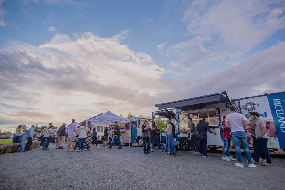 Several people outside food trucks.