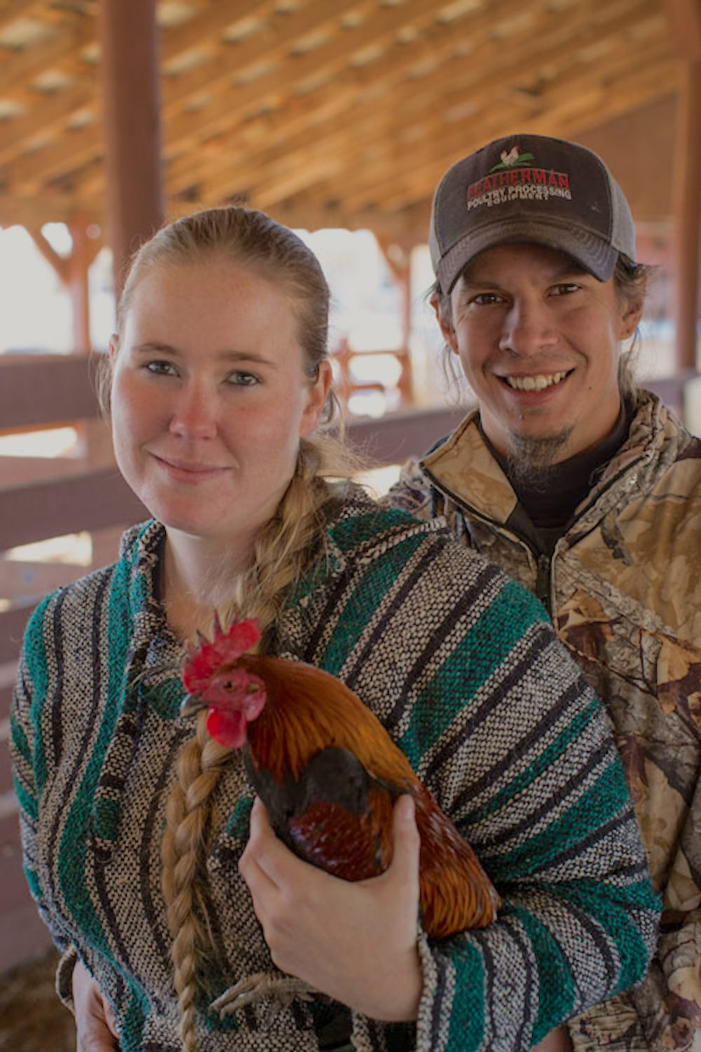 Woman and man hold a rooster