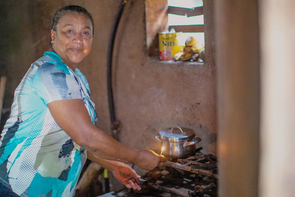 woman lights bio-gas stove