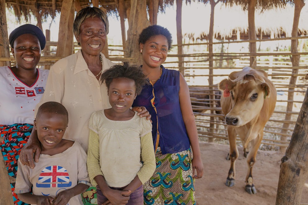 family posing next to heir cow from Heifer