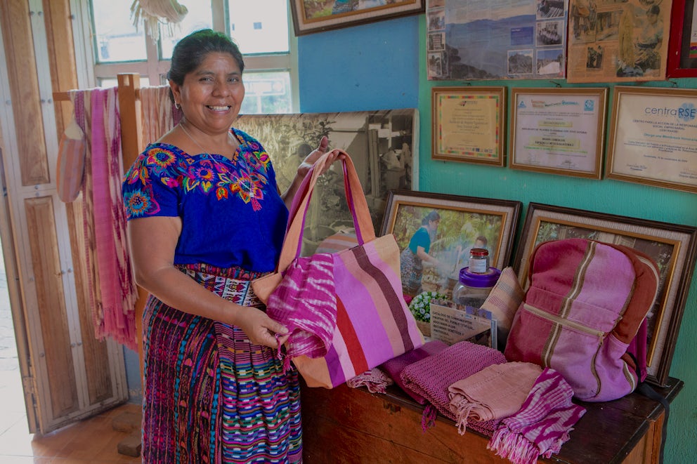 Rosalinda holds up fabric she has dyed