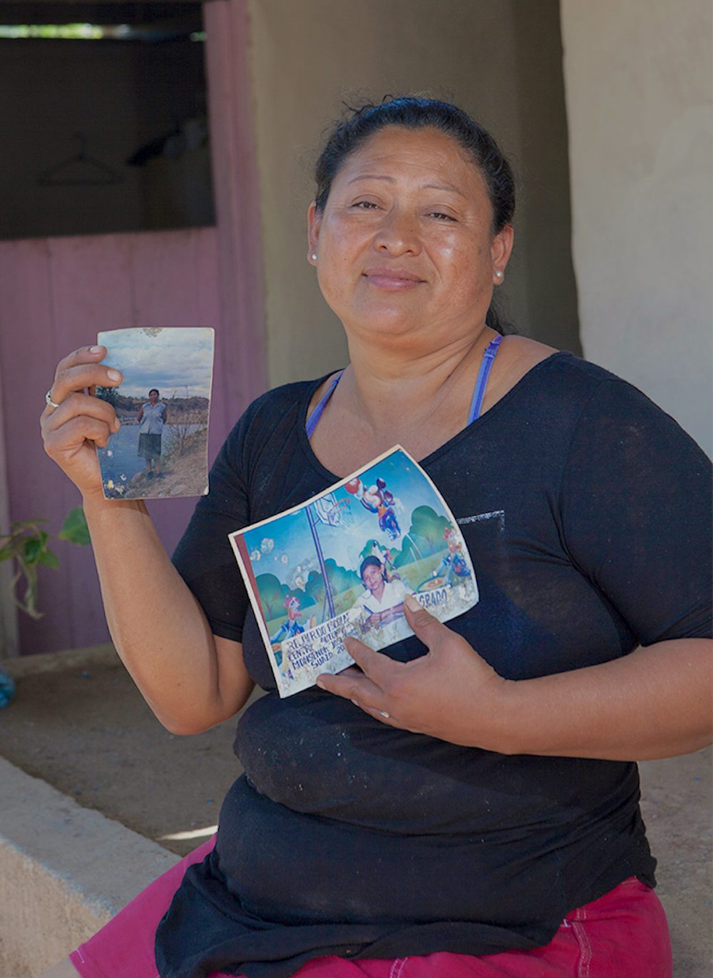 Santos holds up a picture of her mother.