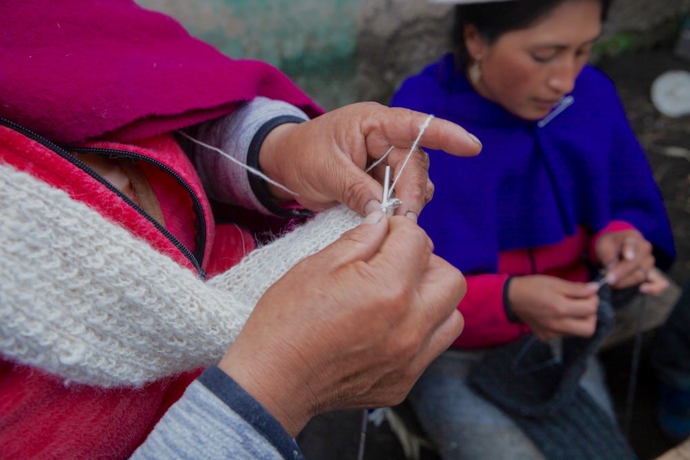 Maria Angela Tacuri Guaman, 45 years, (left, hands only) knits with Miriam Manobanda.