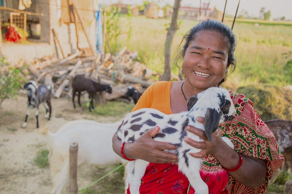 Jit smiles while holding a baby goat