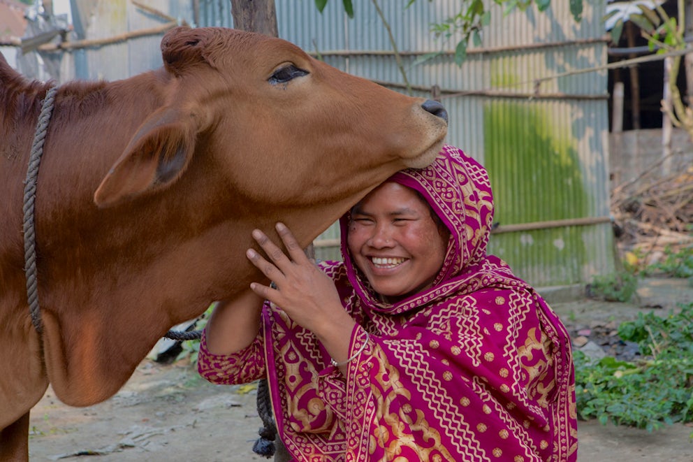 Aeysha hugs her cow and smiles
