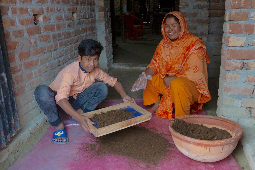 She passes on her knowledge of organic composting and vermiculture to her nephew Arju.