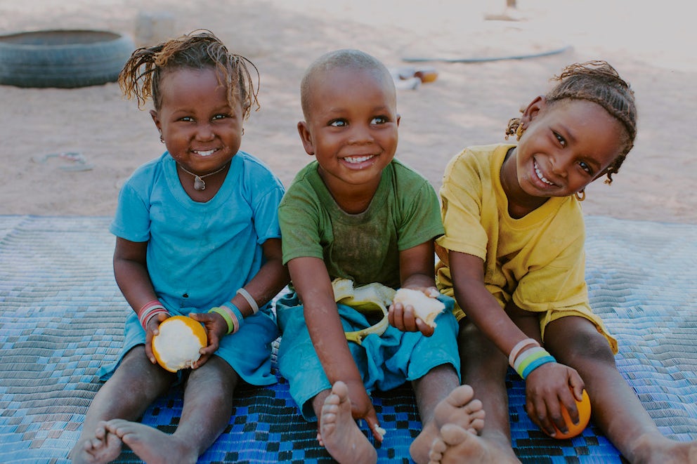 Hawa Sow, Almara Sow and Houleye Sow eat fruit at their home at the Dolly Ranch in Senegal.