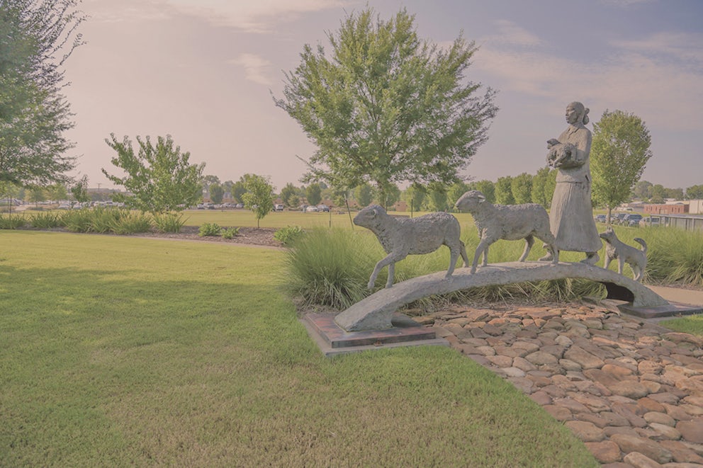 The sculpture is a girl crossing a bridge with animals.