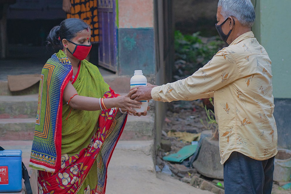 Geeta Rani Jena receives vaccination supplies from a pharmacist in her local village center in Odisha, India. Photo by Pranab K. Aich/Heifer International