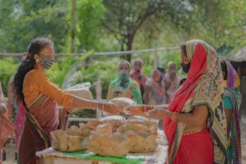Lata Marandi, right, sells her feed at a market in Bharadasol, India.