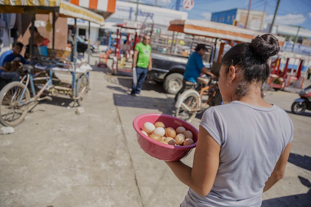 Woman carrying eggs to be delivered to the market.