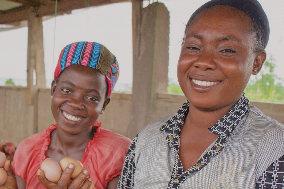 Two women holding eggs and looking proud