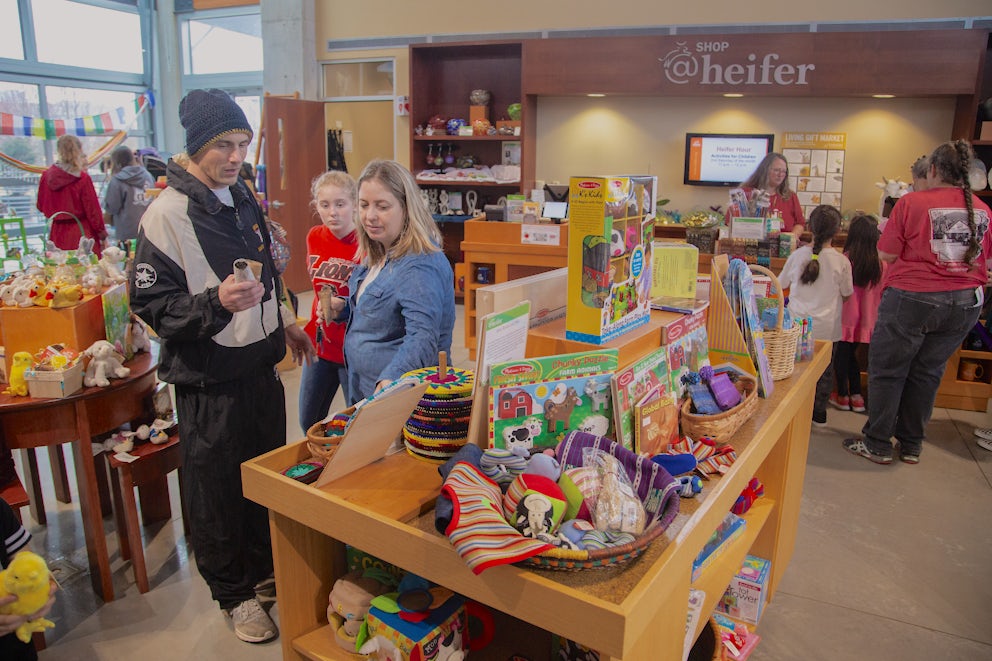 Three people shopping at Heifer, pointing at a product.