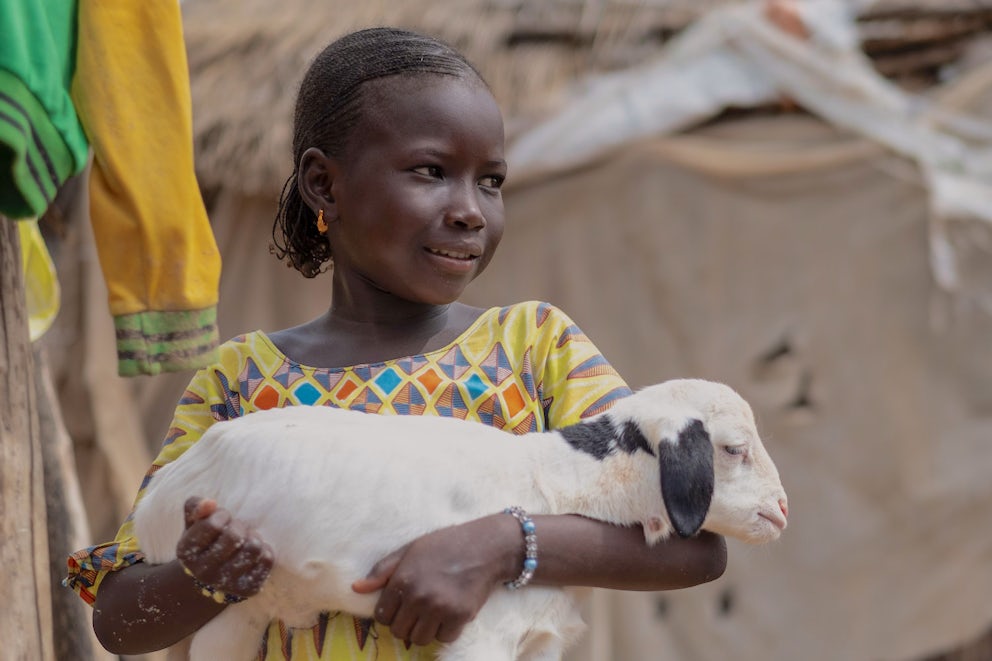 Khardiata, 10, holds a lamb at Nacara village