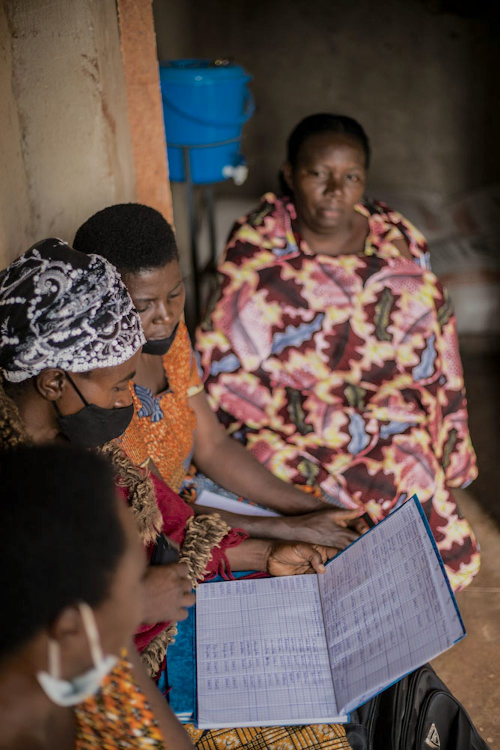 Four women review bookkeeping records in Rwanda.