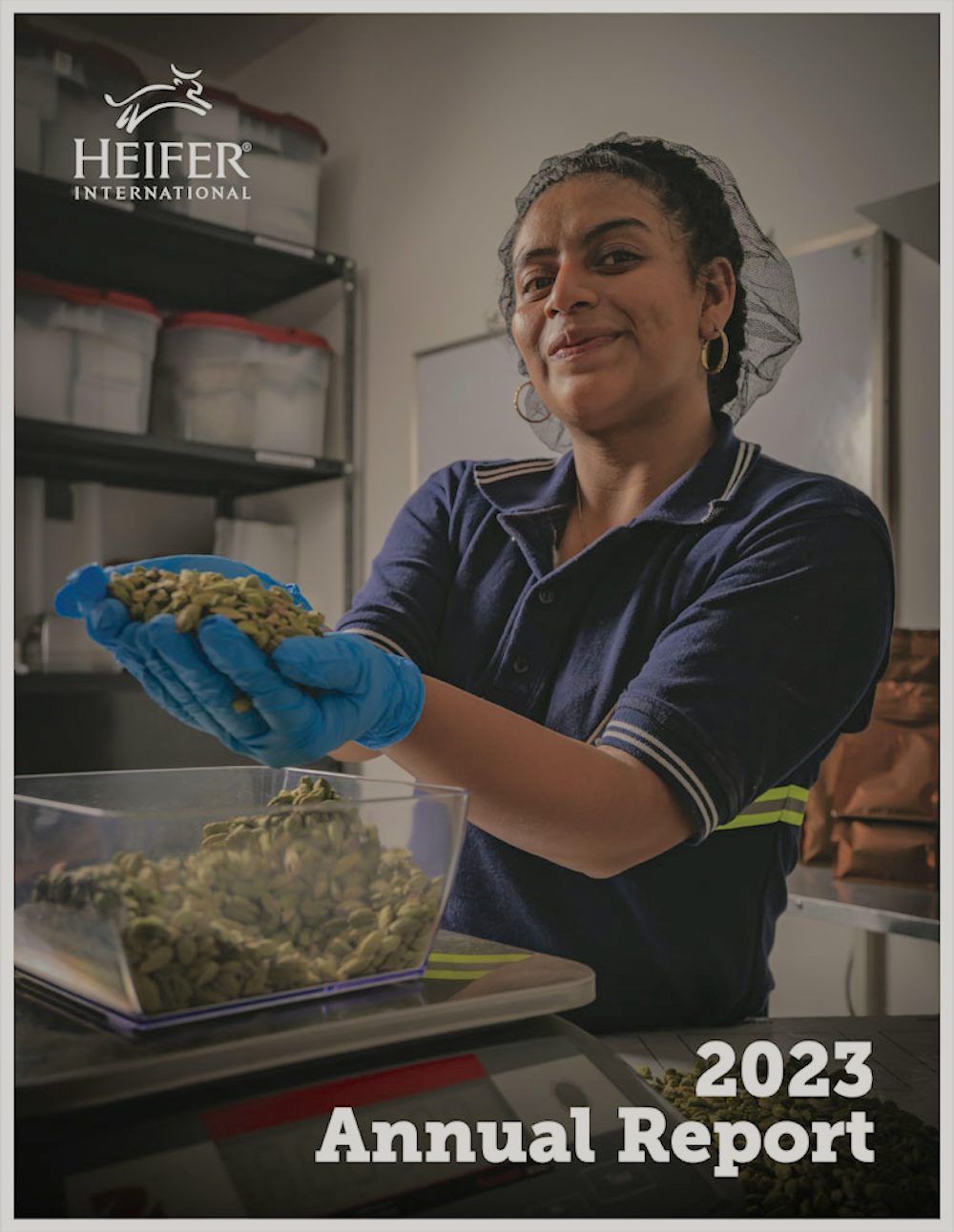 The cover of the Heifer International annual report showing a woman in a hairnet holding handful of cardamom pods.