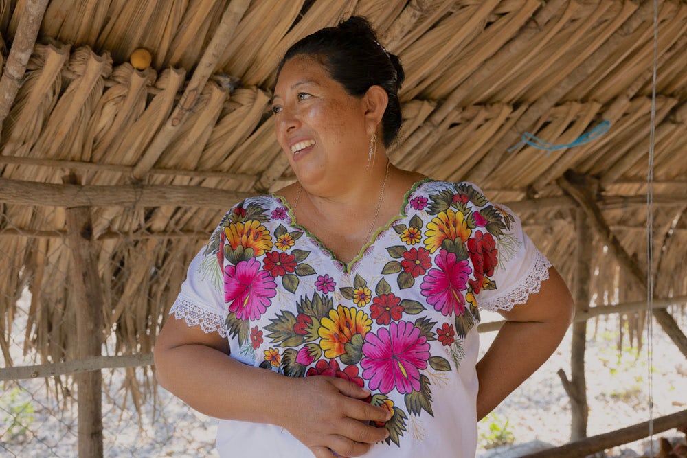 A Mexican woman smiling and looking to her right.