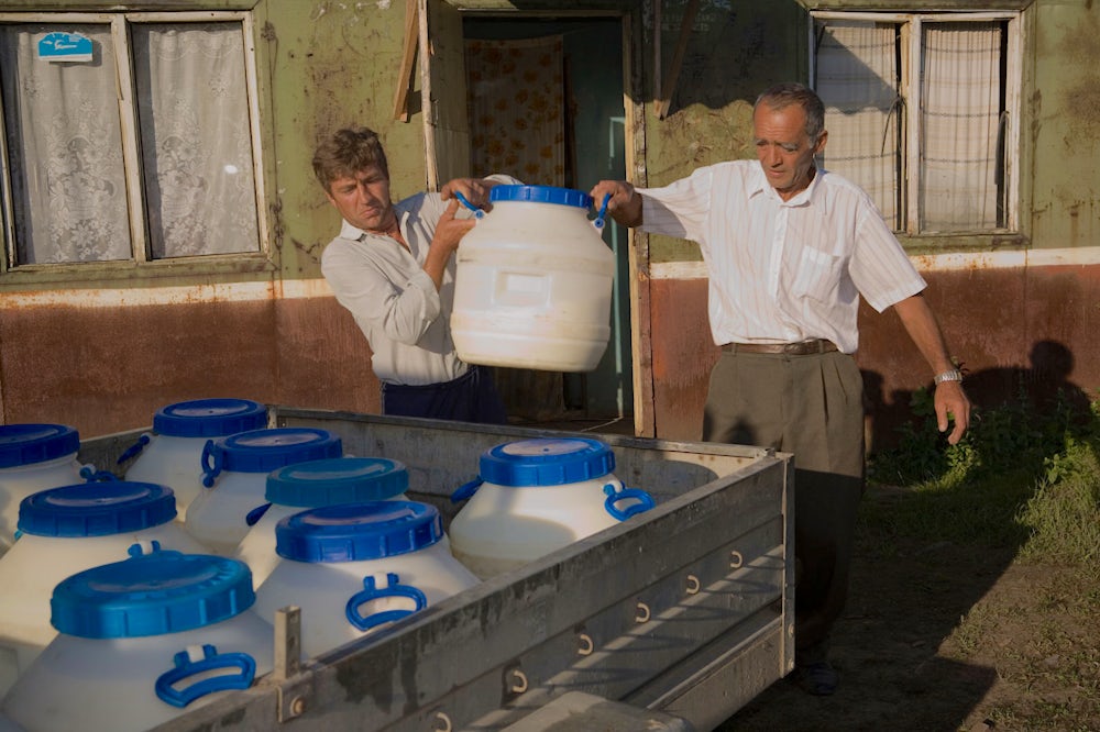 Men load milk into a truck in Ukraine.