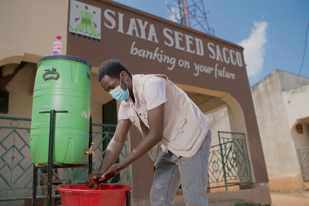 A Kenyan man washes his hands at a hygiene station.